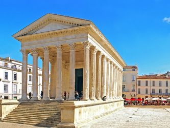 Temple romain avec des colonnes, situé sur une place ensoleillée.