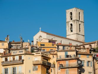 Vue d'un village avec des bâtiments colorés et une tour d'église en arrière-plan.